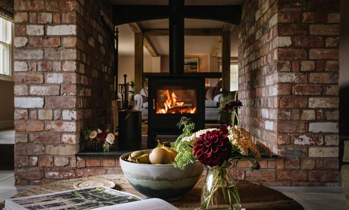 A log burner in a brick fireplace